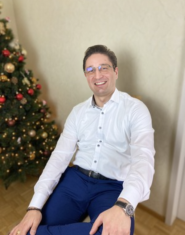 Anton Kozak pe un scaun cu bradul de craciun in plan secundar